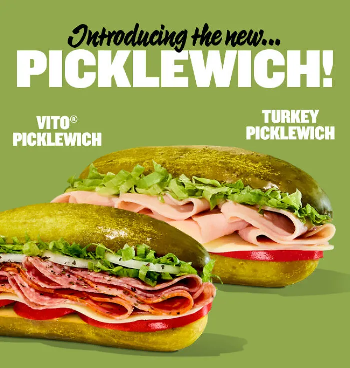 Two nonsensical picklewich sandwiches with deli meats and lettuce between large pickles as buns on a green background.