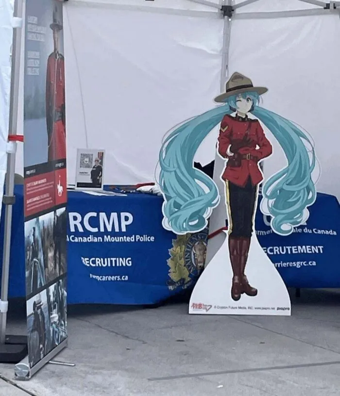 Anime character dressed as Canadian Mounted Police displayed at recruiting booth, showcasing nonsensical things that actually exist.