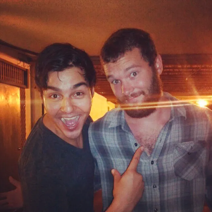 Two men posing happily for a photo, one pointing at the other in a casual indoor setting, celebrity fail humor context.