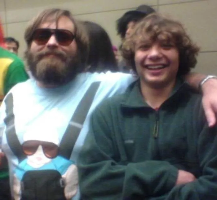 Two men posing and smiling in a crowded indoor setting, featured in Johnny Derp celebrity lookalike photos.