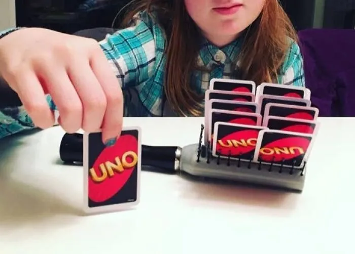 A Kid Got Tired Of Holding Their Cards, So They Used A Brush To Prop Them Up