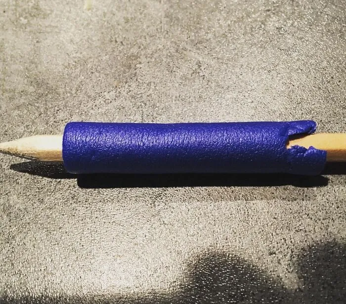 Blue 3D printed grip on pencil, showcasing a creative kids invention with high IQ innovation and surprising design.