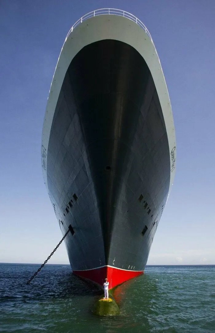 Barco enorme con persona en primer plano mostrando el tamaño real del cuerpo humano y objetos a su escala.