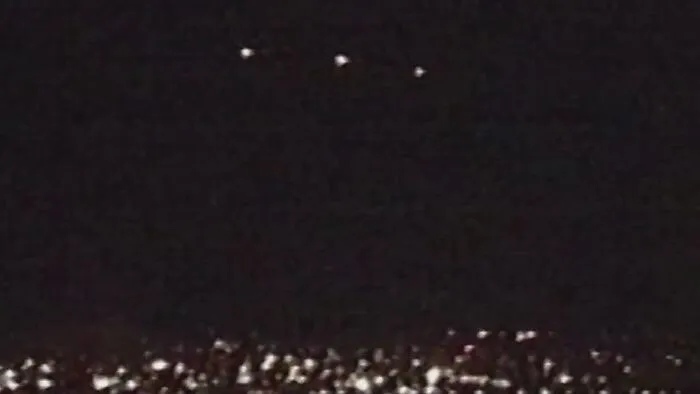Unexplained lights in the night sky over cityscape, an eerie scene with strange and unexplained histories.