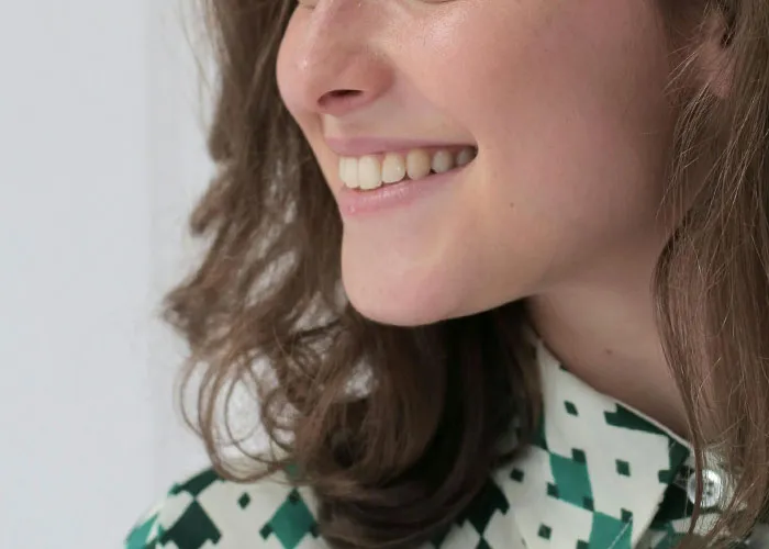 Close-up of a woman smiling, illustrating reactions to the creepiest things women do that cross the line.