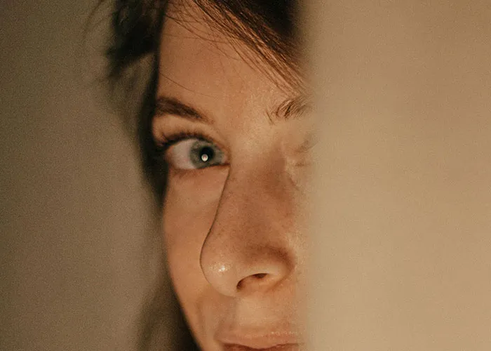 Close-up of a woman’s face with an intense gaze, illustrating creepy behavior that crosses the line for men.