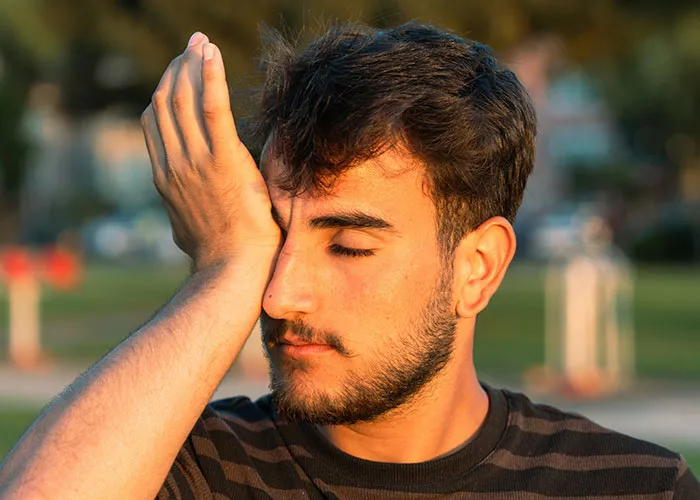 Young man demonstrating a weird body quirk by touching his face, highlighting fascinating human body reactions.