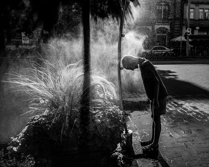 Boy At Water Sprinkler By Scarlett Freund