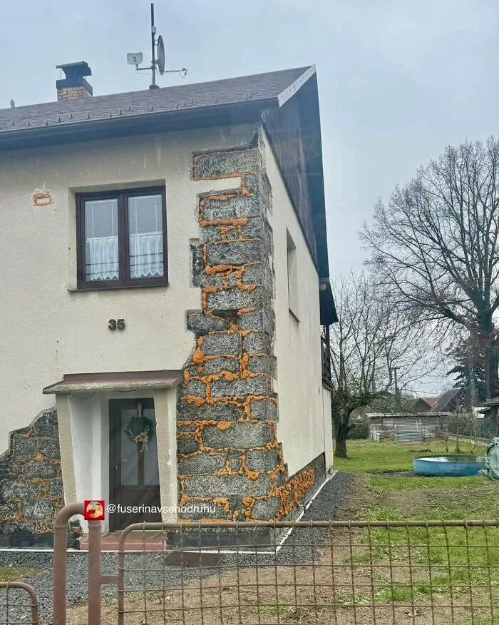 Casa con fallos de construcción visibles, mostrando mala aplicación de cemento y aislamiento en las paredes exteriores.