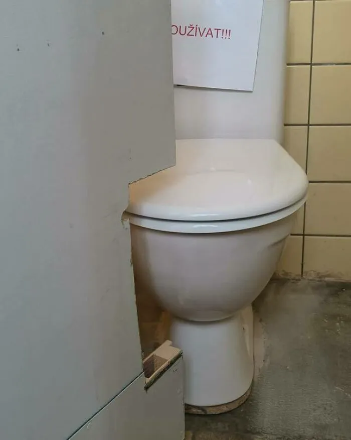 Inodoro con mala construcción y recorte impreciso en pared, ejemplo claro de divertidos fallos de construcción para reír y llorar.