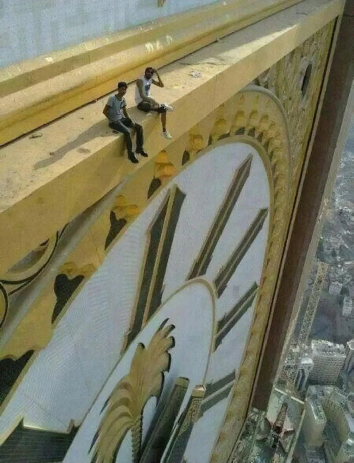 Dos personas sentadas en la Torre del Reloj Abraj Al Bait en La Meca