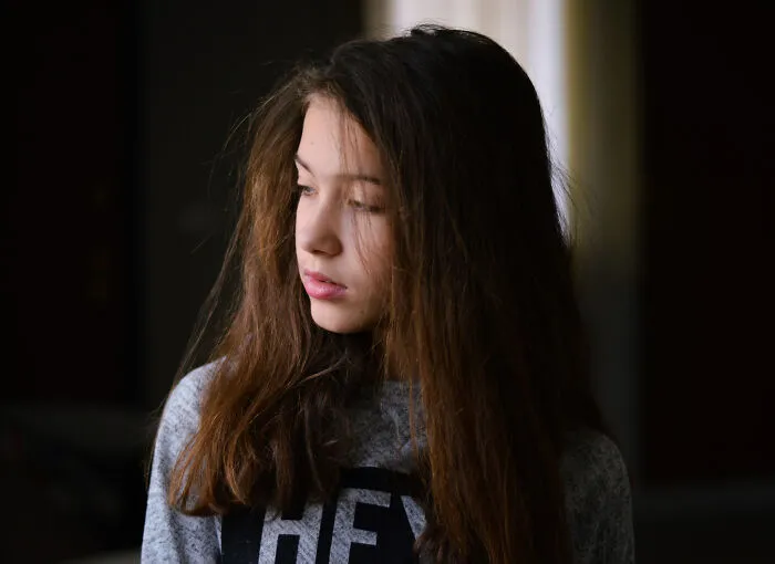 Young woman looking away pensively, capturing the mood of people who saw scary creepy situations.