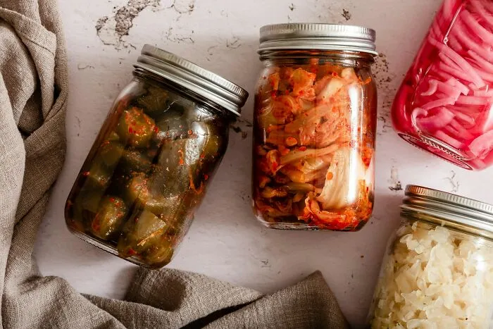 Jars of homemade fermented vegetables on a white surface representing moments people knew they were dating an idiot.