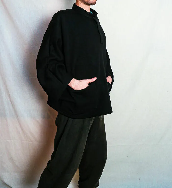 Person wearing all black casual outfit with hands in pockets, illustrating concept of people who got fired by their own dumb actions.