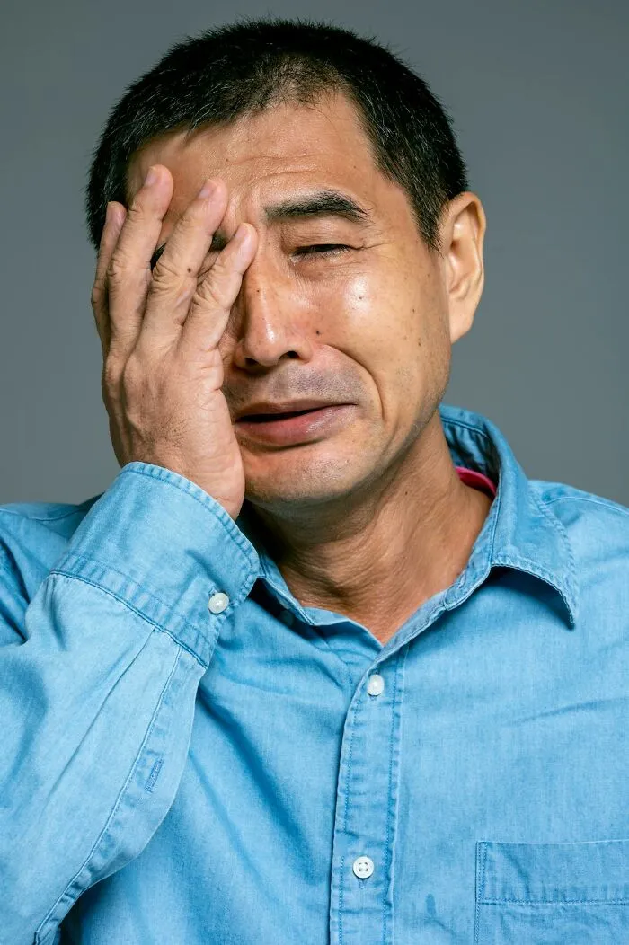 Man in a blue shirt showing regret and frustration, illustrating people who got fired due to their own dumb mistakes.