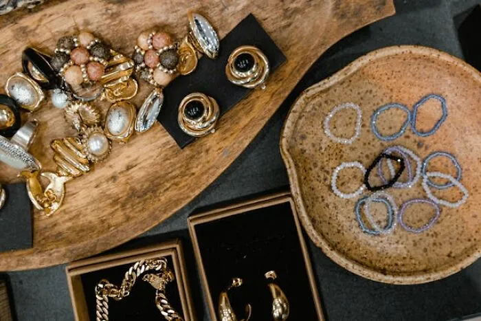 Assorted vintage jewelry and trinkets displayed on wood and ceramic trays, evoking real-life hexes and odd curses.