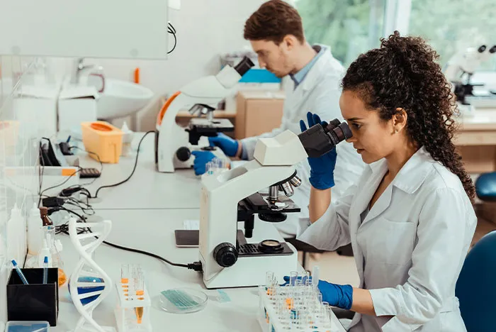 Two doctors examining samples under microscopes in a lab, illustrating accurate diagnoses from House M.D.