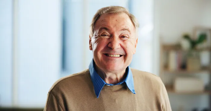 Smiling elderly man indoors, captured in a moment of joy, embodying people who saw scary creepy situations.
