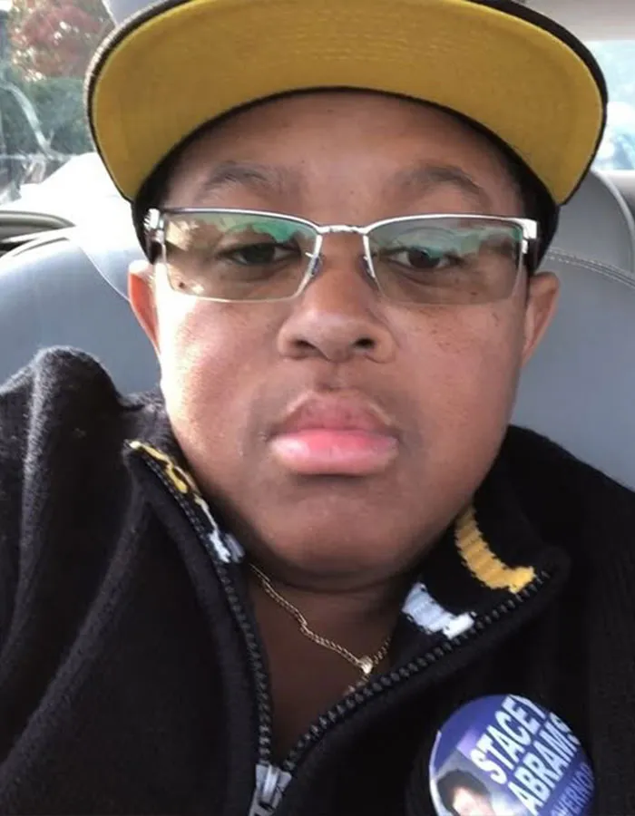 Close-up of a man wearing glasses and a yellow cap, highlighting male stars and their actual height surprises.