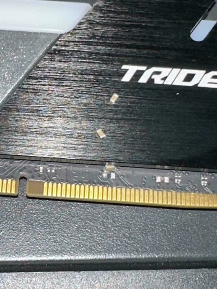 Close-up of broken electronic components on a circuit board, showing damaged parts and poor handling of electronics.