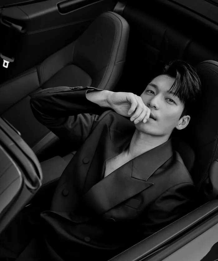 Wi Ha-Joon handsome man in a sleek suit posing confidently inside a luxury car, representing most handsome man in the world 2025.