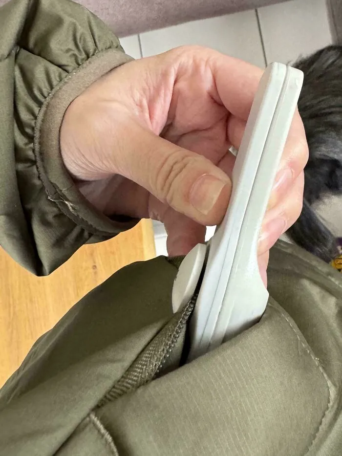 Mano sacando un par de chanclas pequeñas del bolsillo de una chaqueta verde, ejemplo de compras online fallidas.