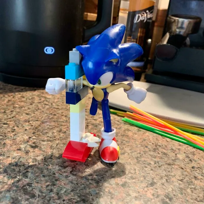Blue Sonic figure interacting with a colorful LEGO invention on a kitchen countertop showcasing kids' creativity.