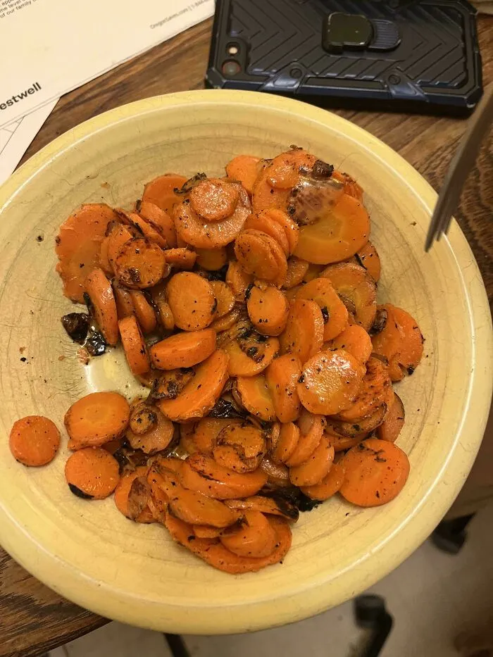 Burnt and overcooked carrot slices on a plate, an example of unholy food pics that look unappetizing.