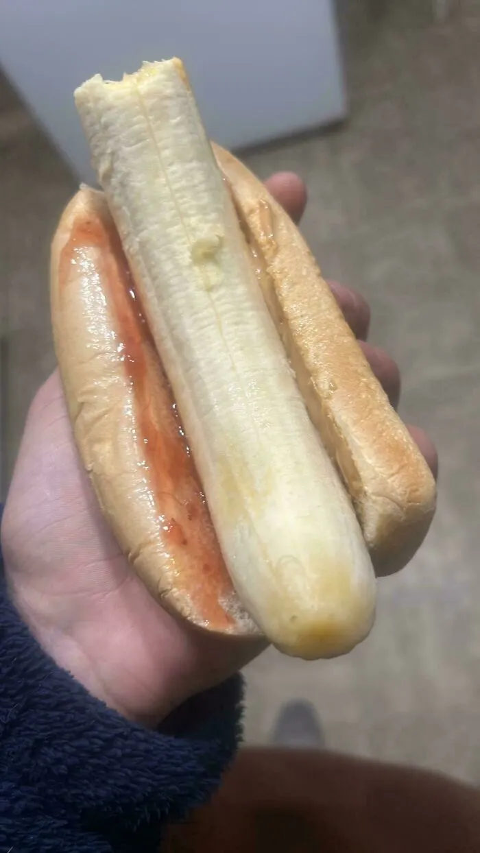 Banana in a hot dog bun with peanut butter and jam, one of the unholy food pics that look anything but appetizing.