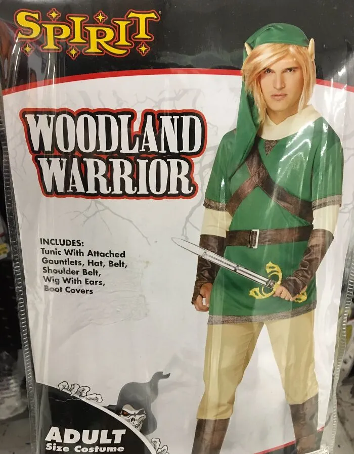 Adult woodland warrior off-brand Halloween costume with green tunic, elf ears, and toy sword in packaging.