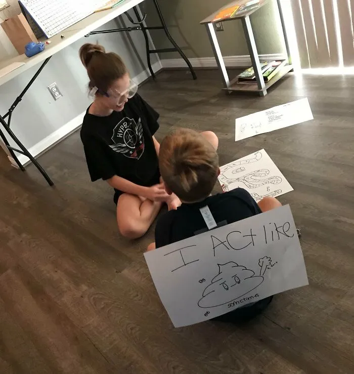 Two kids sitting on the floor with invention drawings, showcasing creativity and surprising parents with new inventions.