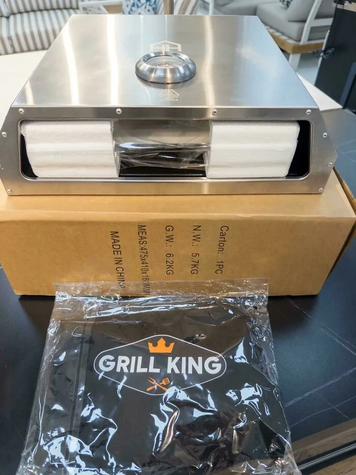 Stainless steel grill missing key parts still sealed on box with Grill King branded accessory bag included in careless online shopping fail.