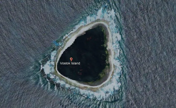 Aerial view of Vostok Island surrounded by ocean waves, an unexpected discovery from Google Earth and Maps.