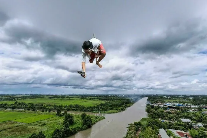 Person captured mid-air over river and fields, an unexpected moment seen through Google Earth and Maps imagery.