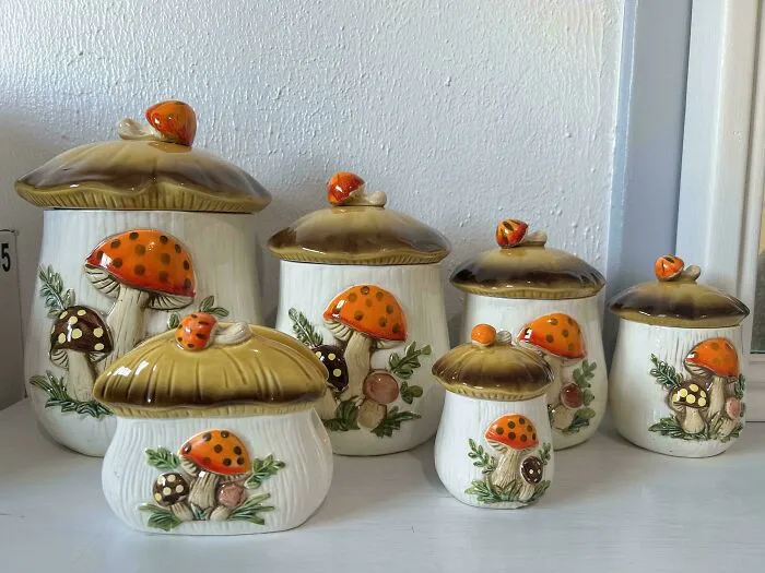 Ceramic canisters with mushroom designs in warm tones, capturing a whimsical cottage core aesthetic for kitchen decor.