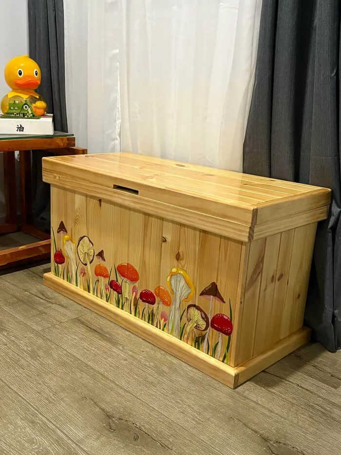 Wooden storage chest with hand-painted mushrooms, fitting perfect cottage core aesthetics in a cozy indoor setting.