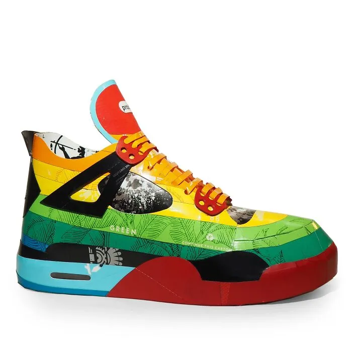 Colorful sneaker sculpture made from recycled waste materials, showcasing witty commentary on modern life through art.