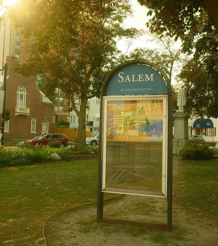 Salem Massachusetts city welcome sign in a park surrounded by trees and autumn foliage, a spooky destination for Halloween.
