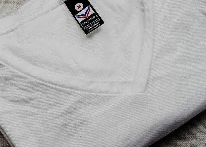 White thermal shirt folded with visible size tag, illustrating a simple example related to loopholes against horrible bosses.