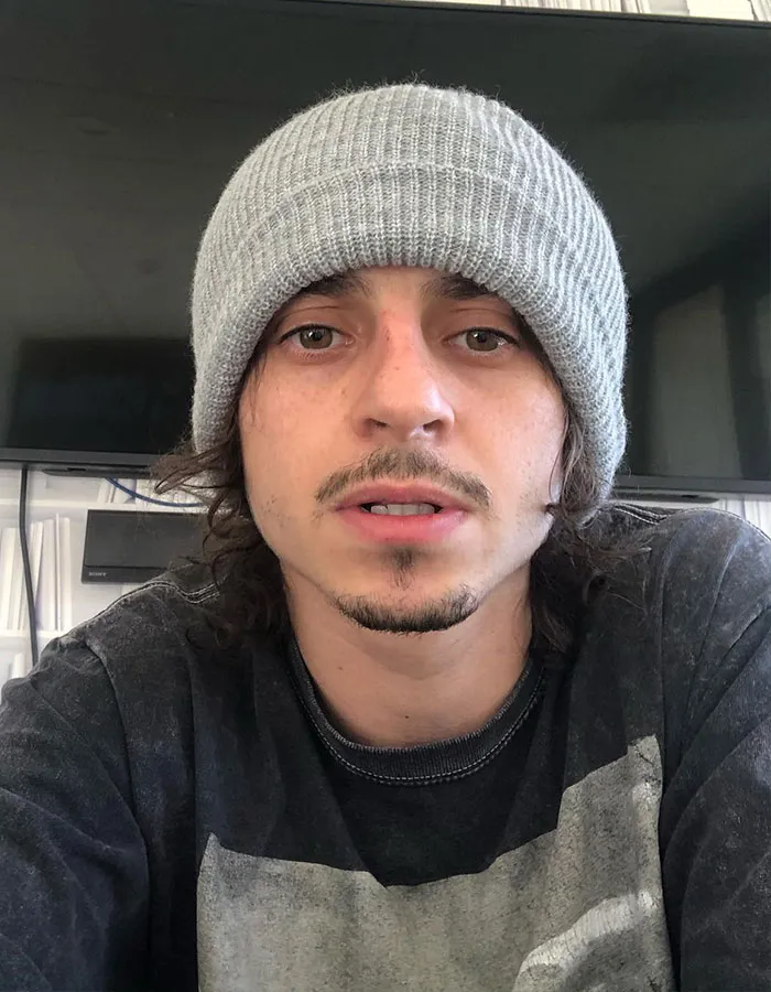 Young male star wearing a gray beanie and black shirt in a casual indoor setting showcasing surprising actual height.