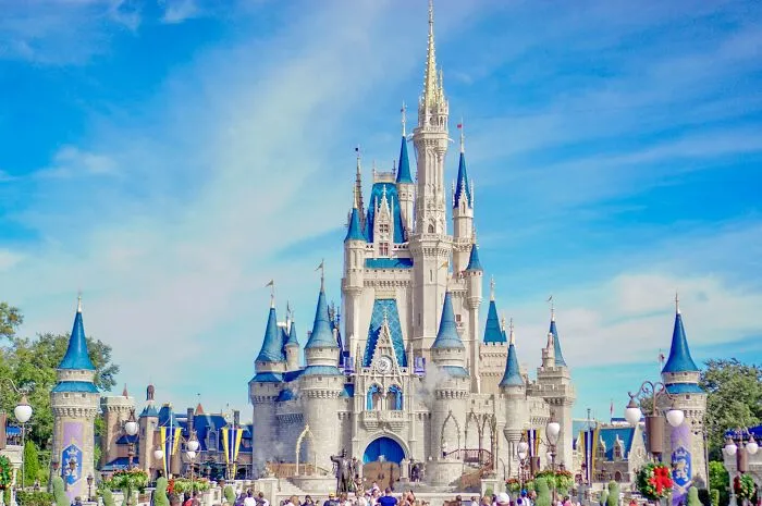 Crowds gather in front of a large castle under a bright blue sky, illustrating long grudges held by many people.
