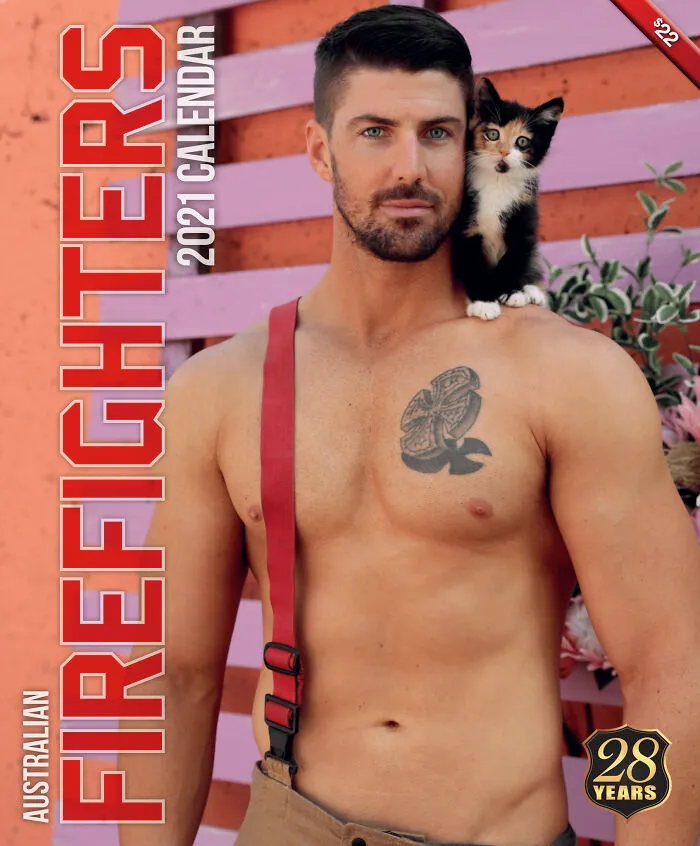 Shirtless Australian firefighter with a kitten on his shoulder posing for a firefighters calendar photo shoot.