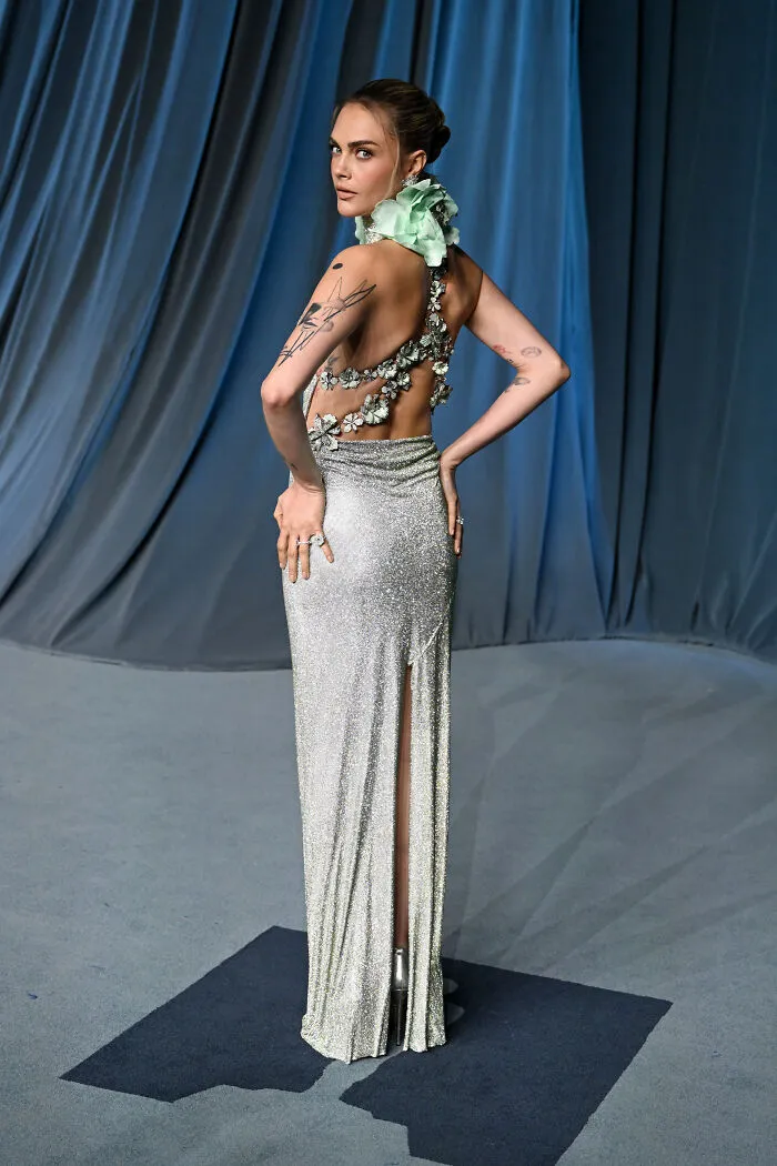 Mujer con vestido brillante de gala y detalles florales, mostrando los aciertos y errores de moda en evento del museo.