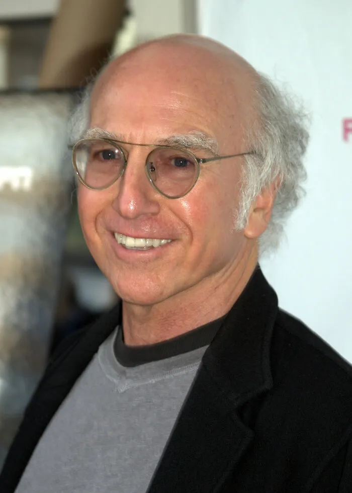Hollywood star with glasses smiling at event, representing actors who found fame after 30 years old.