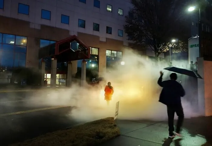 Person walking through street fog at night, capturing the essence of urban life in street photography awards 2025.