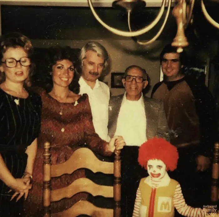 Foto familiar antigua con niño disfrazado de payaso y adultos posando, imagen de fotos familiares incómodas y memorables.