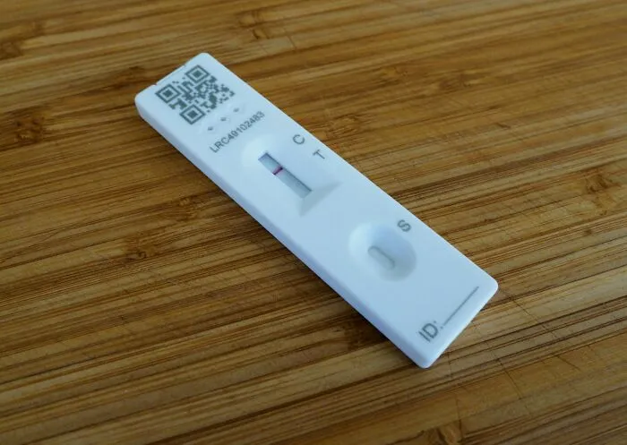 Rapid test device resting on a wooden surface, illustrating concepts related to 57 cheating signs in women.