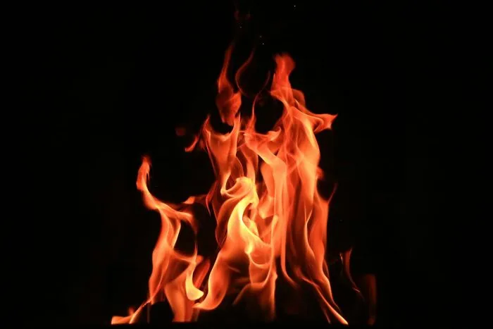 Bright orange and red flames flickering against a black background, symbolizing shocking things popular kids did in school.