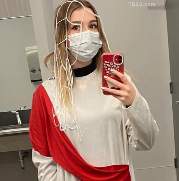 Person wearing a creative Halloween costume with a mask and string web, taking a mirror selfie for Halloween costume ideas.