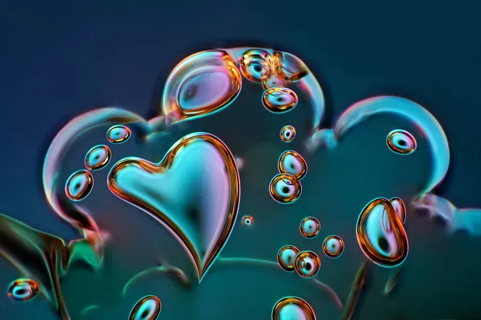 Microscopic image from the 2025 Nikon Small World contest showing colorful bubbles with a heart shape under a microscope.